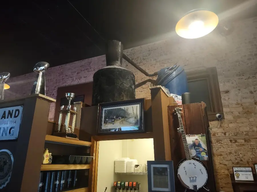 A confiscated copper moonshine still displayed on a shelf above the bar at Old Towne Pub